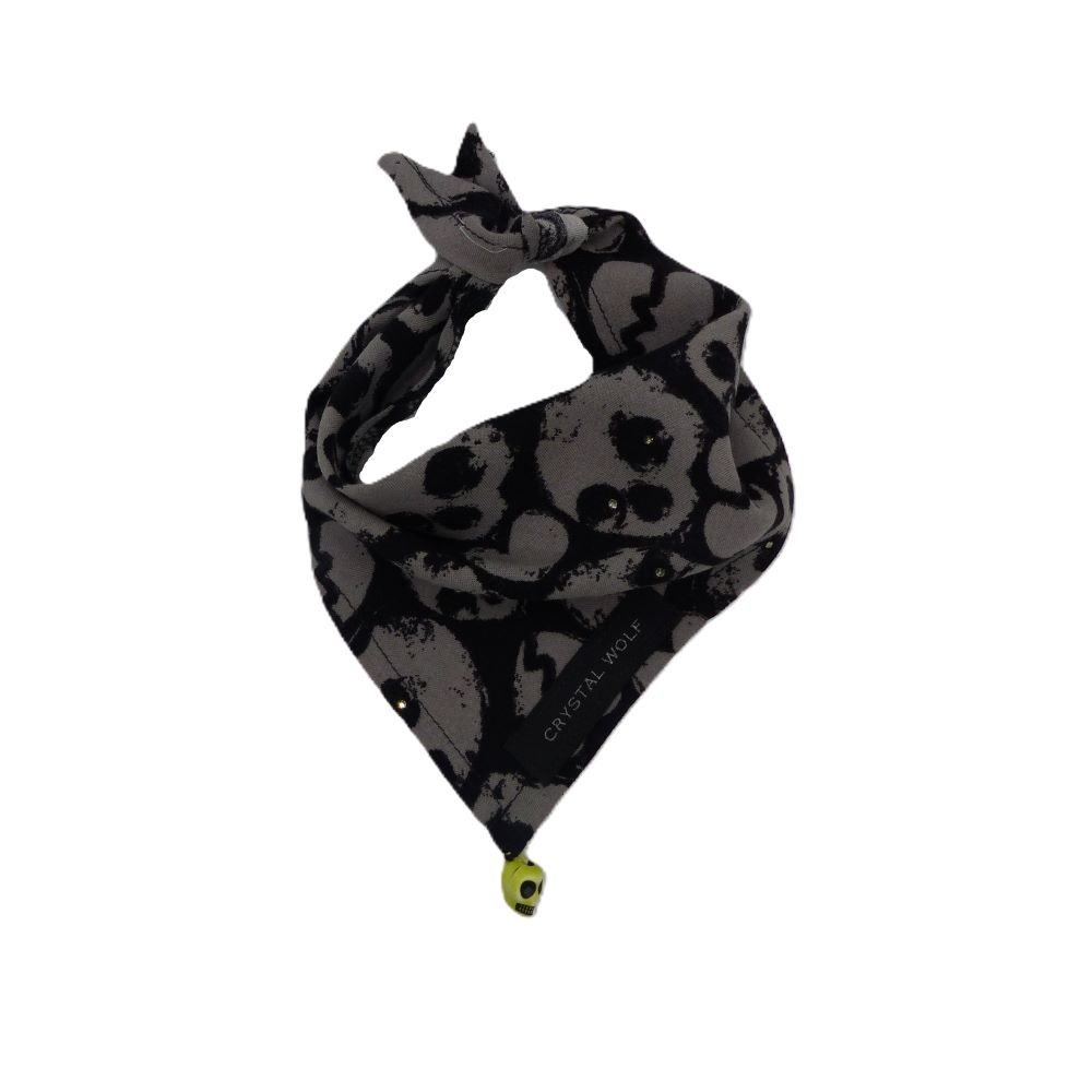Black and grey skull print dog bandana decorated with crystals and a hanging skull charm, displayed lying flat on a surface